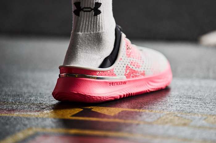 Rear view of pink and white Under Armour shoe.