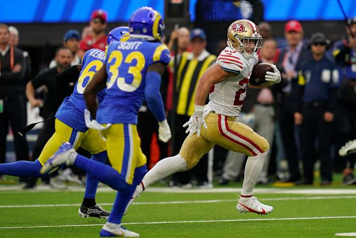 Christian McCaffrey eludes two tackles on a run for the Niners.