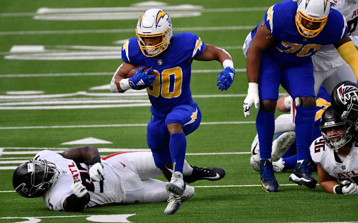 Dec 13, 2020; Inglewood, California, USA; Los Angeles Chargers running back Austin Ekeler (30) breaks free from Atlanta Falcons defensive end Allen Bailey (93) during a first quarter running play at SoFi Stadium. Mandatory Credit: Robert Hanashiro-USA TODAY Sports