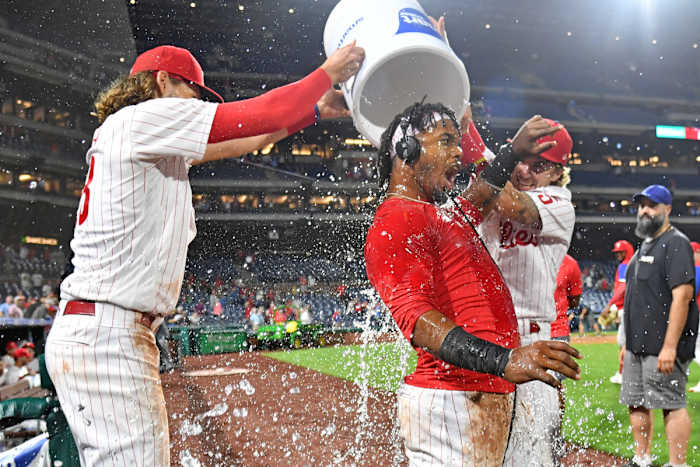 Alec Bohm and Bryson Stott help Jean Segura celebrate a walk-off single.