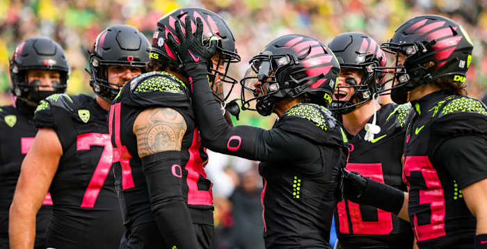 Oregon Ducks tight end Cam McCormick celebrates a touchdown against the UCLA Bruins with wide receiver Kris Hutson and teammates.