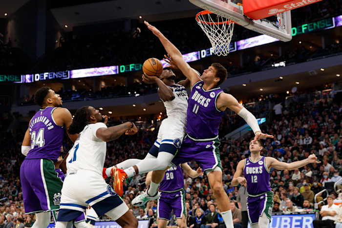 Anthony Edwards shoots a layup defended tightly by Brook Lopez