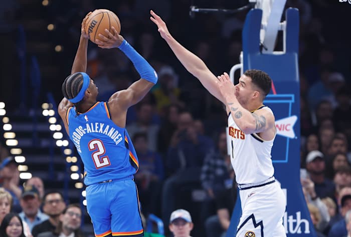 Jan 31, 2024; Oklahoma City, Oklahoma, USA; Oklahoma City Thunder guard Shai Gilgeous-Alexander (2) shoots as Denver Nuggets forward Michael Porter Jr. (1) defends during the first quarter at Paycom Center.© Alonzo Adams-USA TODAY Sports