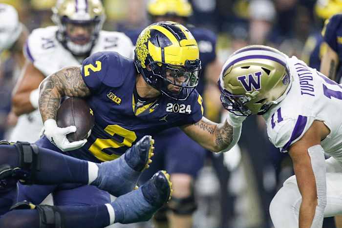 Michigan running back Blake Corum (2) runs against Washington linebacker Alphonzo Tuputala (11) during the first half of the national championship game at NRG Stadium in Houston on Monday, Jan. 8, 2024.