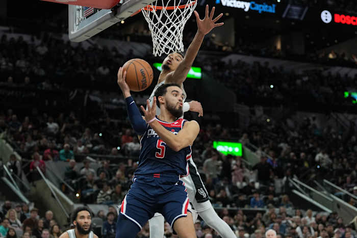 Jan 29, 2024; San Antonio, Texas, USA; Washington Wizards guard Tyus Jones (5) looks to pass under the arm of San Antonio Spurs center Victor Wembanyama (1) in the second half at Frost Bank Center.