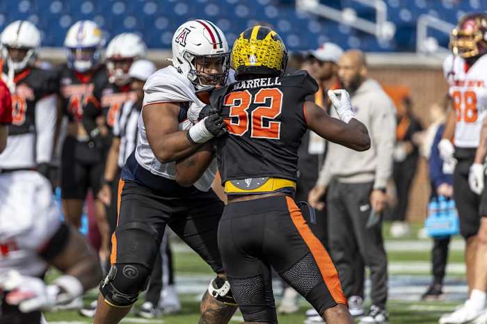 Feb 1, 2024; Mobile, AL, USA; National offensive lineman Jordan Morgan of Arizona (77) blocks National edge Jaylen Harrell of Michigan (32) during practice for the National team at Hancock Whitney Stadium. Mandatory Credit: Vasha Hunt-USA TODAY Sports  