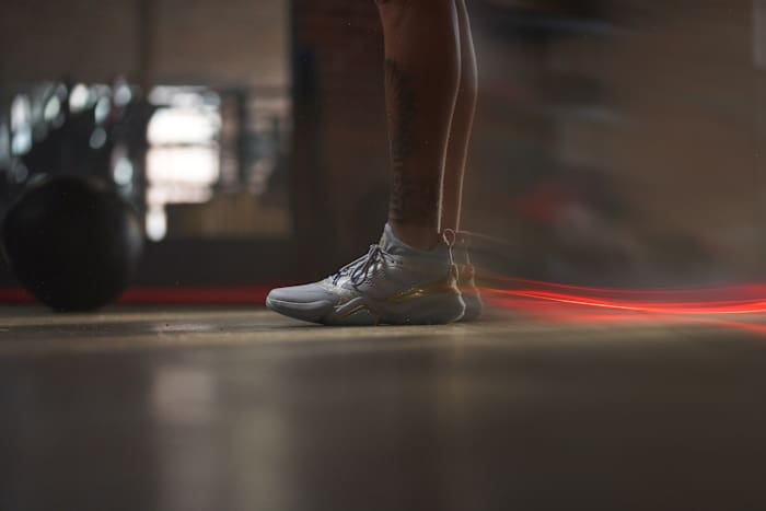 Side view of Patrick Mahomes' grey and gold adidas shoes.