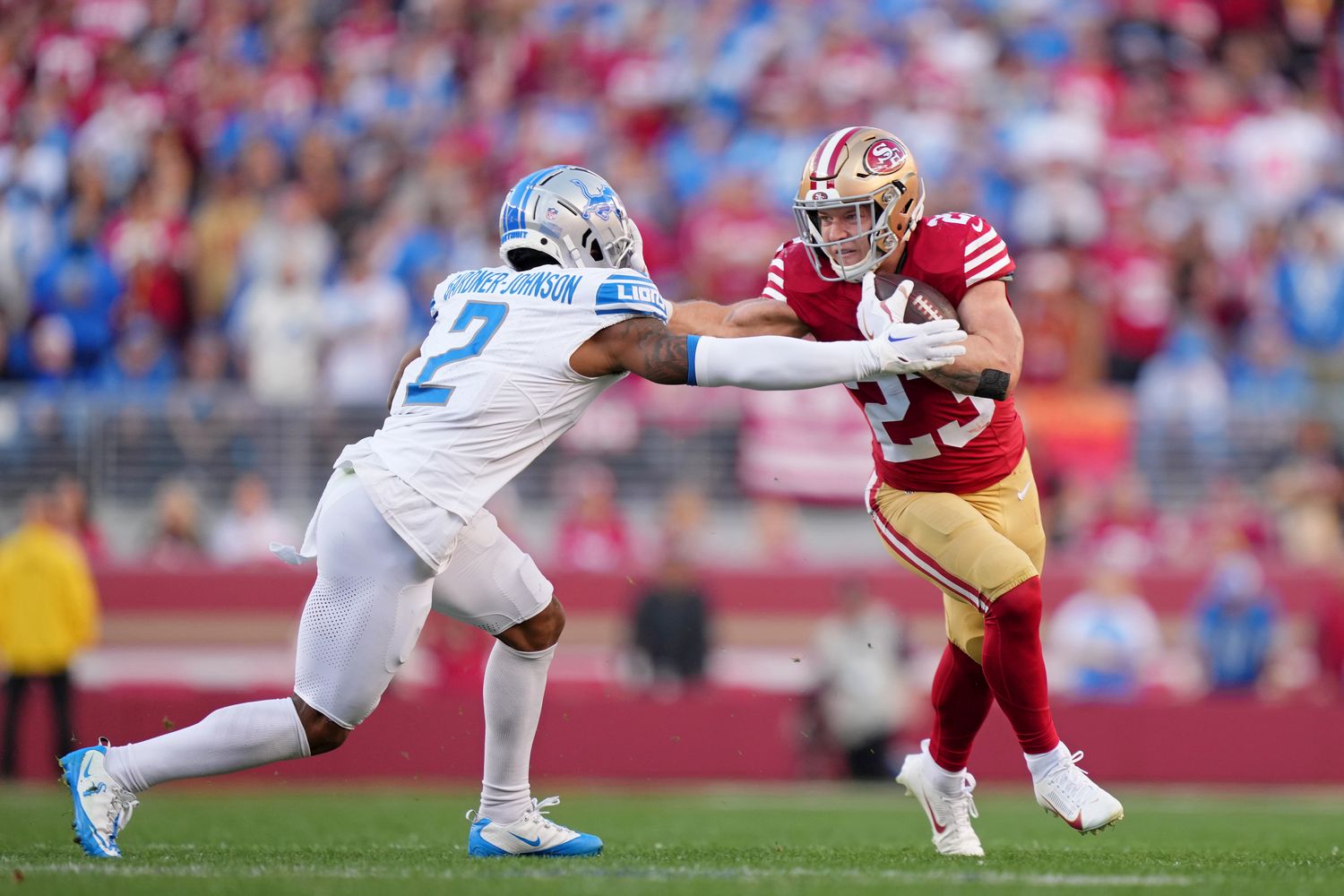San Francisco 49ers running back Christian McCaffrey stiff-arms Detroit Lions safety C.J. Gardner-Johnson.