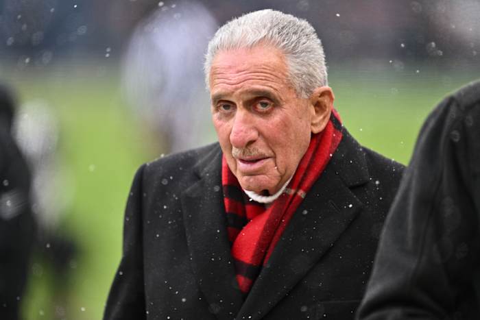Arthur Blank wears a scarf amid snow on the field