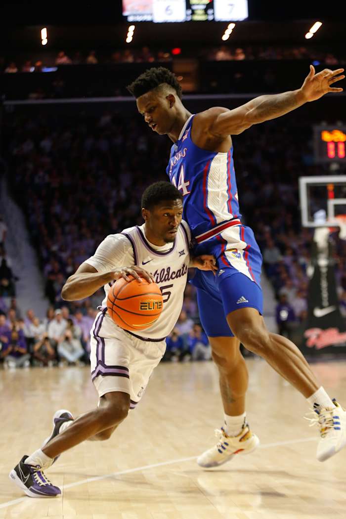 Kansas State junior guard Cam Carter (5) avoids Kansas junior forward KJ Adams Jr. (24) in the first half of the Sunflower Showdown inside Bramlage Coliseum Monday, February 5, 2024.