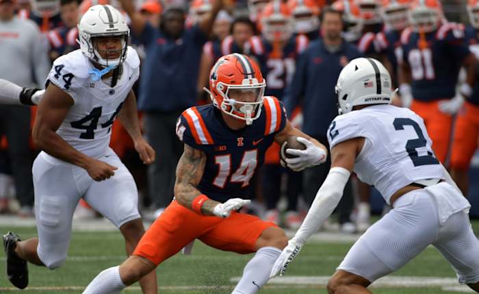 Sep 16, 2023; Champaign, Illinois, USA; Illinois Fighting Illini wide receiver Casey Washington (14) runs the ball against Penn State Nittany Lions safety Keaton Ellis (2) during the first half at Memorial Stadium. Mandatory Credit: Ron Johnson-USA TODAY Sports