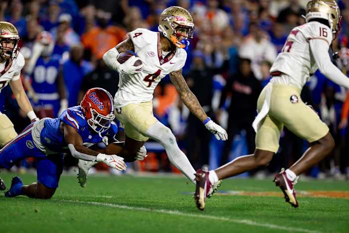 Florida State Seminoles wide receiver Keon Coleman (4) rushes with the ball for a touchdown breaking the tackle from Florida Gators linebacker Scooby Williams (17) during the second half at Steve Spurrier Field at Ben Hill Griffin Stadium in Gainesville, FL on Saturday, November 25, 2023. [Matt Pendleton/Gainesville Sun]
