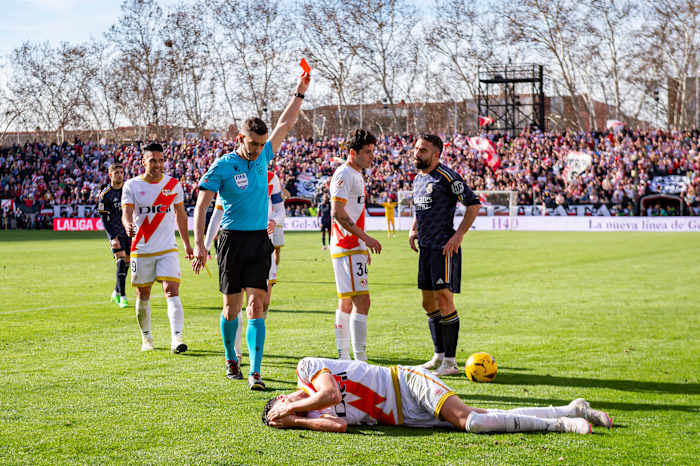 Referee Alejandro Muniz pictured showing a red card to Dani Carvajal (right) after the Real Madrid defender lashed out at Rayo Vallecano midfielder Kike Perez (bottom) during a La Liga game in February 2024