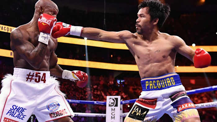 Manny Pacquiao (R) throws punch at Yordenis Ugas during their WBA welterweight title fight at T-Mobile Arena in Las Vegas, Nevada. Manny Pacquiao recieves shock disqualification from Olympic organizers. ETHAN MILLER/GETTY IMAGES.