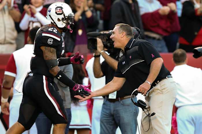 Shawn Elliott high-fives an offensive player running back to the sidelines after a touchdown (17th Oct., 2015)