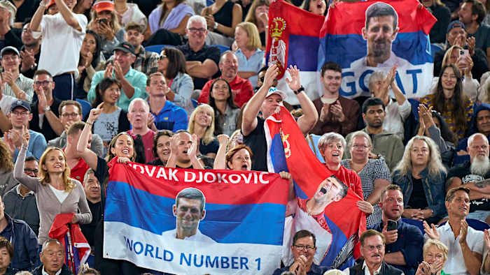 Fans supports Novak Djokovic with Serbian flags donning his face.