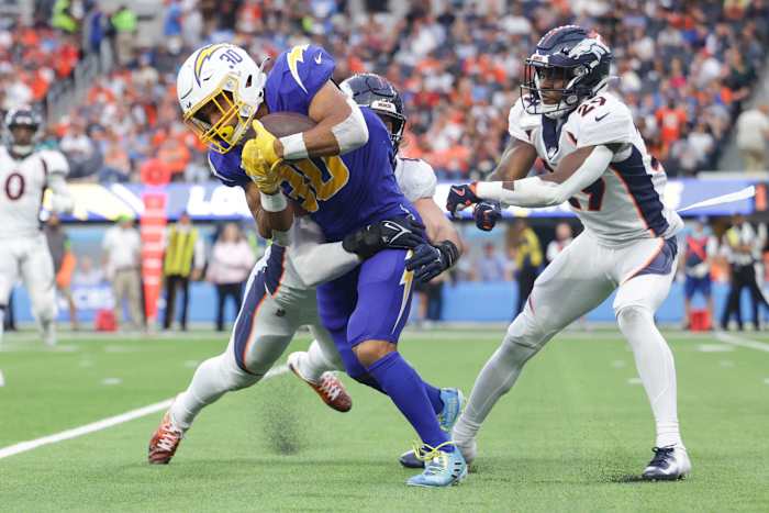 Los Angeles Chargers running back Austin Ekeler (30) is tackled by Denver Broncos inside linebacker Alex Singleton (49) during the second half at SoFi Stadium.