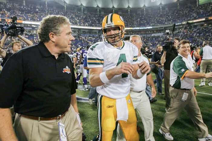 Peter King walks on the field alongside Brett Favre