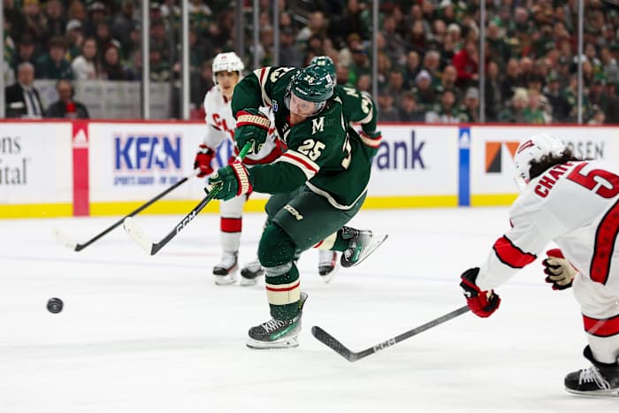 Feb 27, 2024; Saint Paul, Minnesota, USA; Minnesota Wild defenseman Jonas Brodin (25) shoots as Carolina Hurricanes defenseman Jalen Chatfield (5) defends during the second period at Xcel Energy Center.