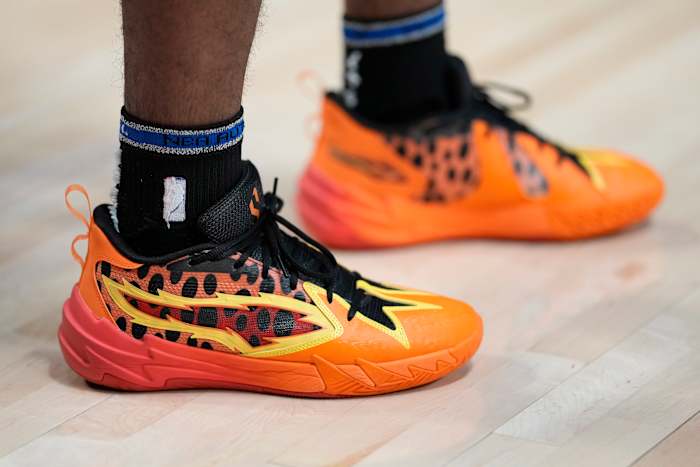 Portland Trail Blazers guard Scoot Henderson's orange and black PUMA sneakers.