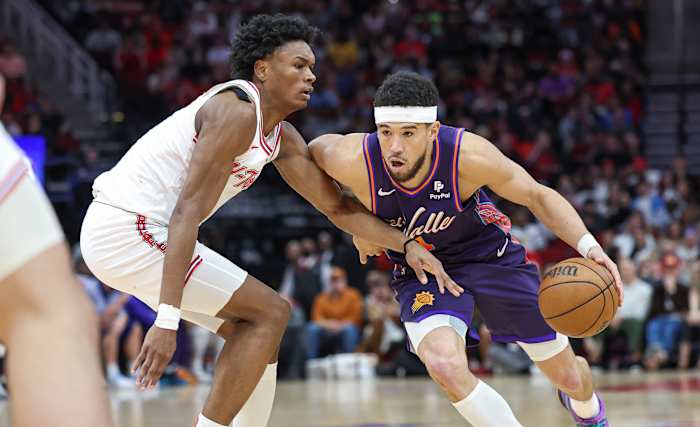 Phoenix Suns guard Devin Booker (1) drives with the ball as Houston Rockets forward Amen Thompson (1) defends during the fourth quarter at Toyota Center.