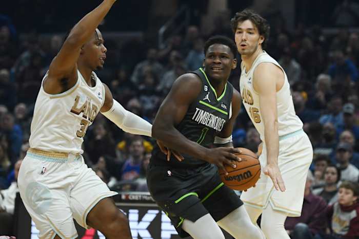Nov 13, 2022; Cleveland, Ohio, USA; Minnesota Timberwolves guard Anthony Edwards (1) drives to the basket against Cleveland Cavaliers forward Isaac Okoro (35) and forward Cedi Osman (16) during the first half at Rocket Mortgage FieldHouse.