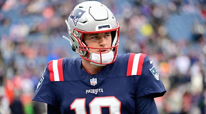 Patriots quarterback Mac Jones looks on before a game.