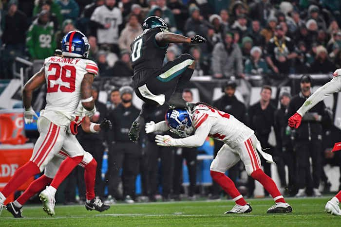 Dec 25, 2023; Philadelphia, Pennsylvania, USA; Philadelphia Eagles running back D'Andre Swift (0) leaps over New York Giants safety Dane Belton (24) during the fourth quarter at Lincoln Financial Field.