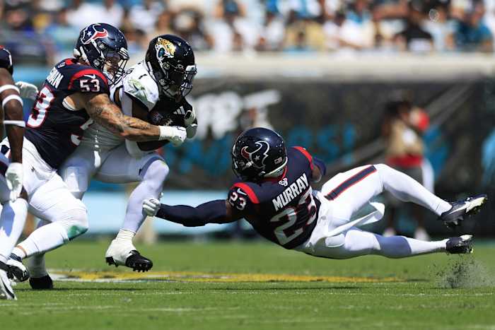 Jacksonville Jaguars running back Travis Etienne Jr. (1) rushes for yards against Houston Texans linebacker Blake Cashman (53) and safety Eric Murray (23) during the second quarter of an NFL football matchup Sunday, Sept. 24, 2023 at EverBank Stadium in Jacksonville, Fla. The Houston Texans defeated the Jacksonville Jaguars 37-17.