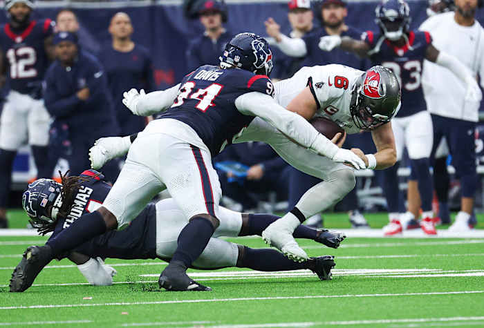 Buccaneers quarterback Baker Mayfield (6) dives for a first down as Houston Texans defensive tackle Khalil Davis (94) attempts to make a tackle during the fourth quarter at NRG Stadium.