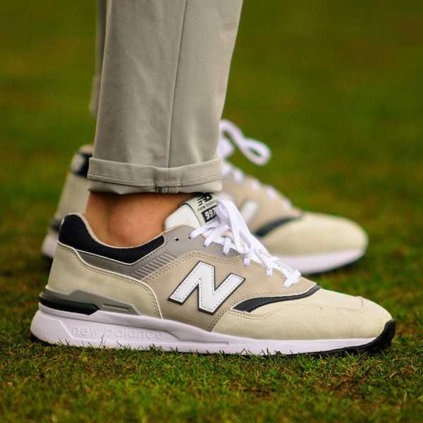 Side view of tan and white New Balance golf shoes.