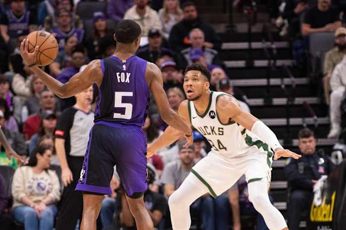 Sacramento Kings guard De'Aaron Fox (5) looks to pass the ball against Milwaukee Bucks forward Giannis Antetokounmpo (34)