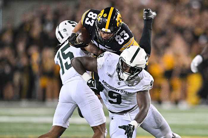 Sep 30, 2023; Iowa City, Iowa, USA; Michigan State Spartans defensive lineman Zion Young (9) and defensive back Angelo Grose (15) tackle Iowa Hawkeyes tight end Erick All (83) during the fourth quarter at Kinnick Stadium. Mandatory Credit: Jeffrey Becker-USA TODAY Sports