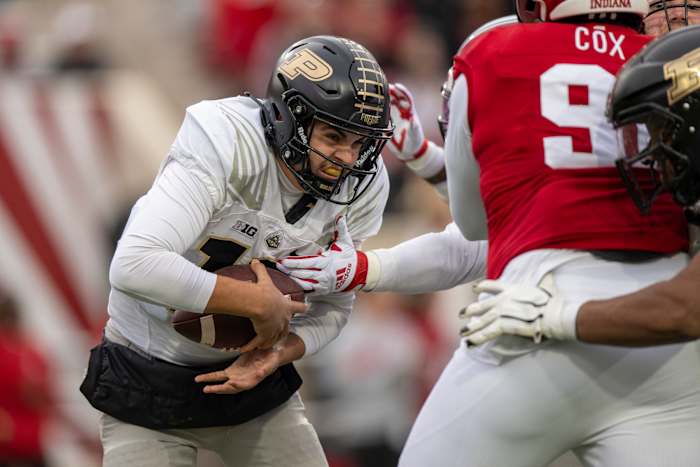 Aidan O’Connell runs with the ball tucked under one hand as Indiana defenders try to reach it