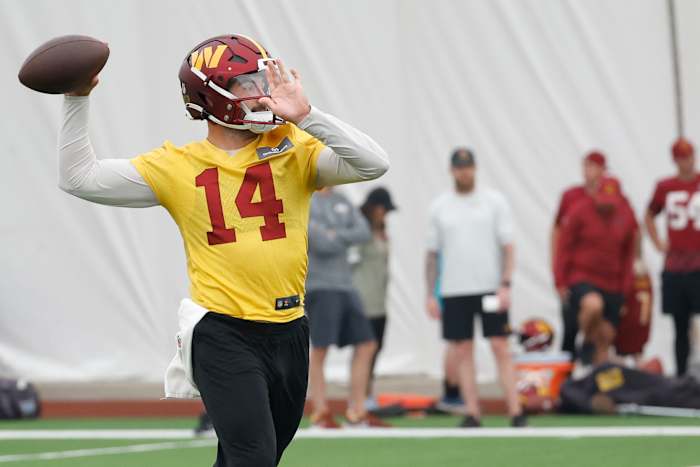Sam Howell brings his arm back to throw the football at camp