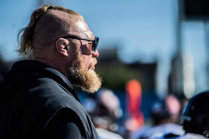 WWE superstar and former UFC fighter Brock Lesnar outside with sunglasses looking on.