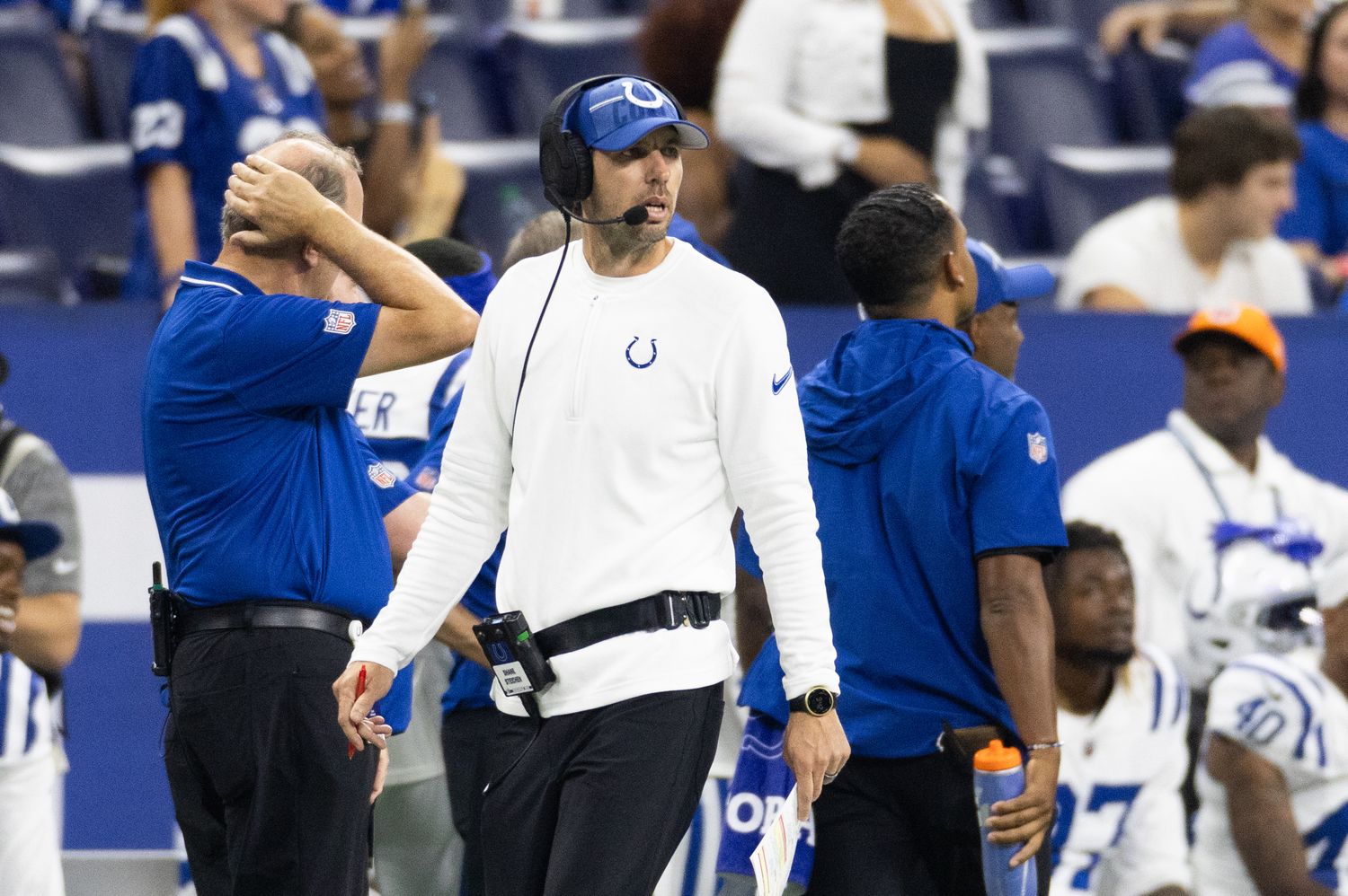 indianapolis Colts head coach Shane Steichen walks on the sideline and looks onto the field with a headset on his head