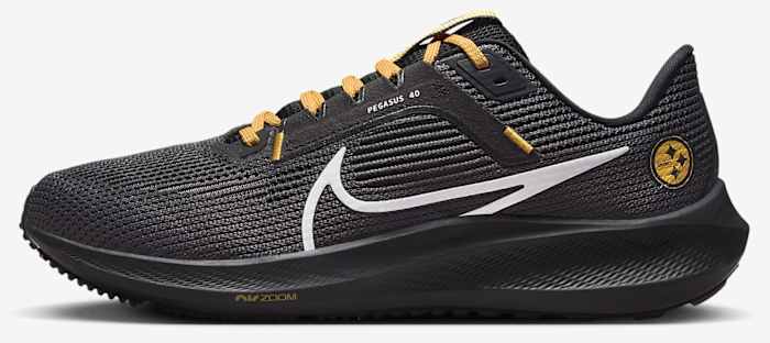 Side view of black and yellow Nike running shoes.