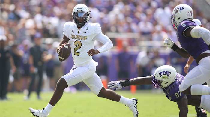 Colorado QB Shedeur Sanders runs away from TCU pass rushers.