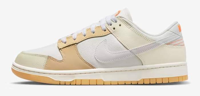Side view of a white and tan Nike Dunk Low sneaker.