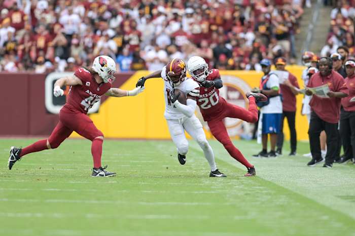 Washington Commanders wide receiver Terry McLaurin (17) cuts in-between Arizona Cardinals linebacker Dennis Gardeck (45) and cornerback Marco Wilson (20) as assistant head coach/offensive coordinator Eric Bieniemy look on during the first half at FedExField.