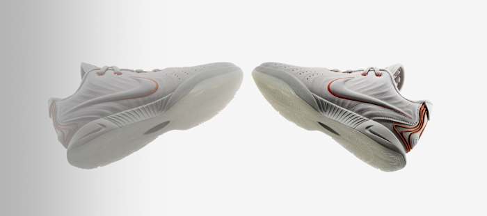 Side view of LeBron James' white and orange Nike basketball shoes.