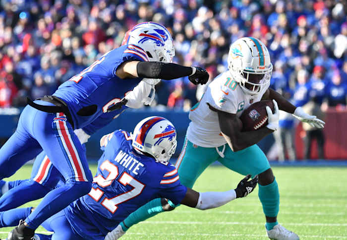 Miami Dolphins wide receiver Tyreek Hill (10) tries to get away from Buffalo Bills cornerback Tre'Davious White (27) and safety Jordan Poyer (21) and cornerback Taron Johnson (7)