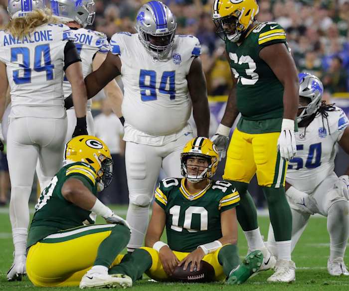 Packers QB Jordan Love sits on the ground after being sacked against the Lions