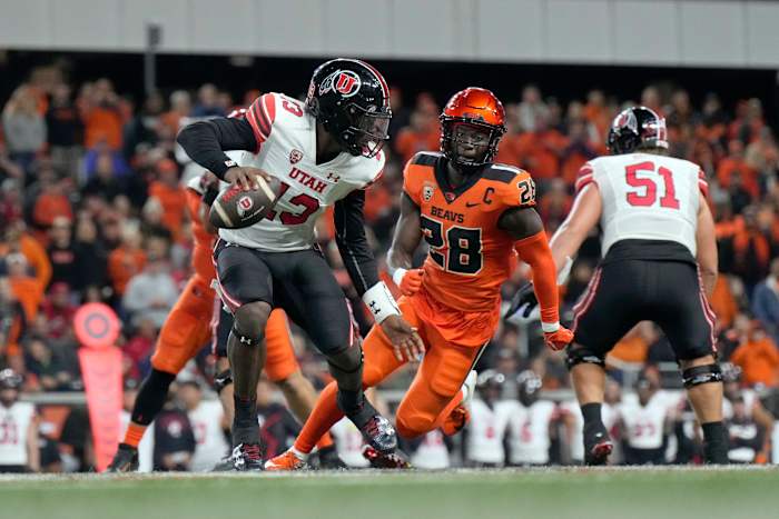 Sep 29, 2023; Corvallis, Oregon, USA; Utah Utes quarterback Nate Johnson (13) scrambles under pressure from Oregon State Beavers defensive back Kitan Oladapo (28) during the second half at Reser Stadium. Mandatory Credit: Soobum Im-USA TODAY Sports