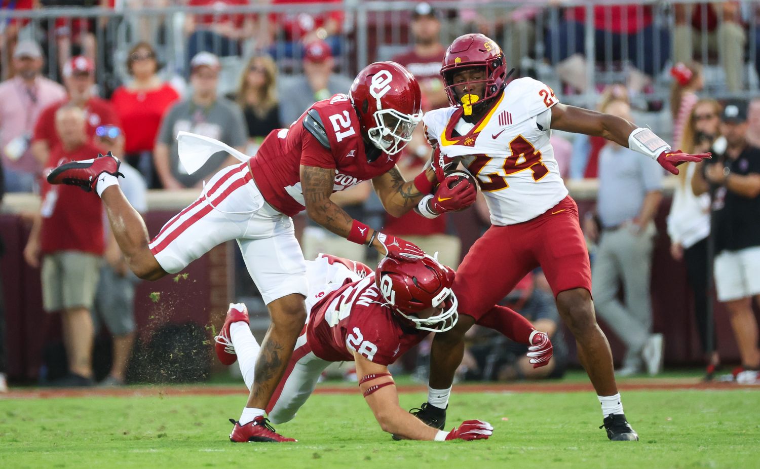 Oklahoma Sooners defensive back Reggie Pearson (21) and Oklahoma Sooners linebacker Danny Stutsman (28) tackle Iowa State Cyclones running back Abu Sama III (24)