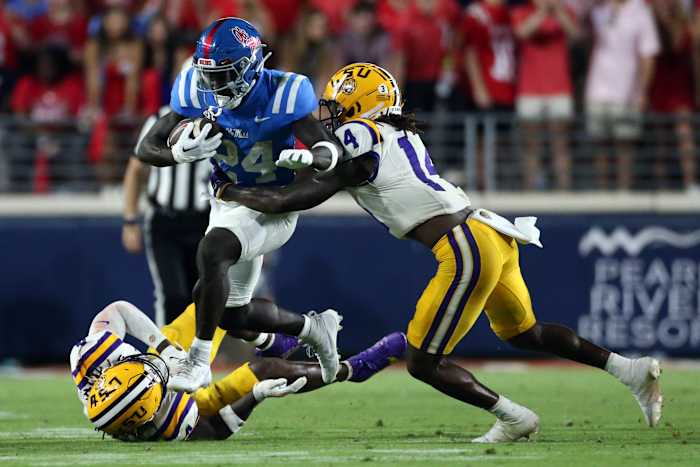Sep 30, 2023; Oxford, Mississippi, USA; Mississippi Rebels running back Ulysses Bentley IV (24) runs the ball as Tigers linebacker Harold Perkins Jr. (4) and defensive back Andre' Sam (14) make the tackle during the second half at Vaught-Hemingway Stadium. Mandatory Credit: Petre Thomas-USA TODAY Sports