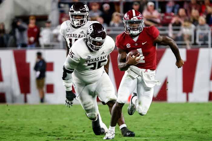 Alabama Crimson Tide quarterback Jalen Milroe (4) scrambles away from Texas A&M Aggies defensive lineman McKinnley Jackson (35) during the first half at Bryant-Denny Stadium.