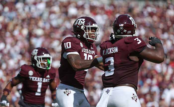 Texas A&M Aggies defensive linemen Fadil Diggs (No. 10) and McKinnley Jackson (No. 3) celebrate a sack against Alabama Crimson Tide quarterback Jalen Milroe