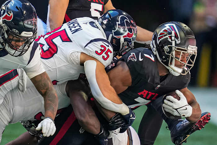 Falcons running back Bijan Robinson (7) is tackled by Houston Texans linebacker Jake Hansen (35) during the first half at Mercedes-Benz Stadium.
